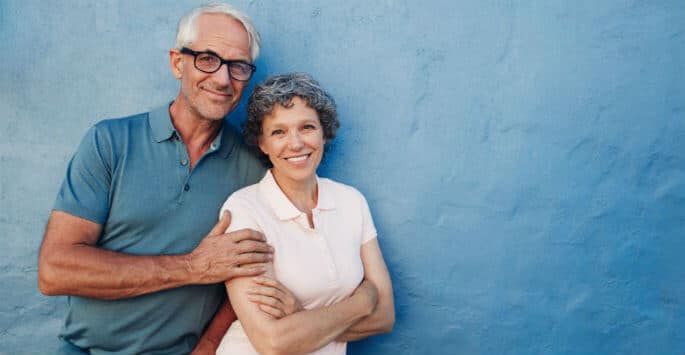 Happy older couple against a blue wall